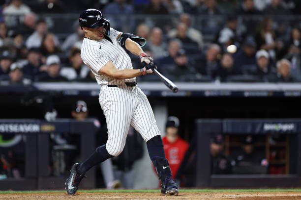 Giancarlo Stanton #27 of the New York Yankees hits a home run.