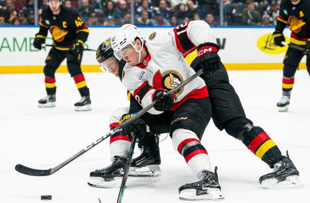 Canucks vs. Senators: Shane Pinto (#12) of the Ottawa Senators faces off against Tyler Myers (#57) of the Vancouver Canucks.