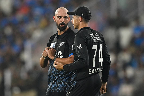 New Zealand's Daryl Mitchell (L) and captain Mitchell Santner speak. 